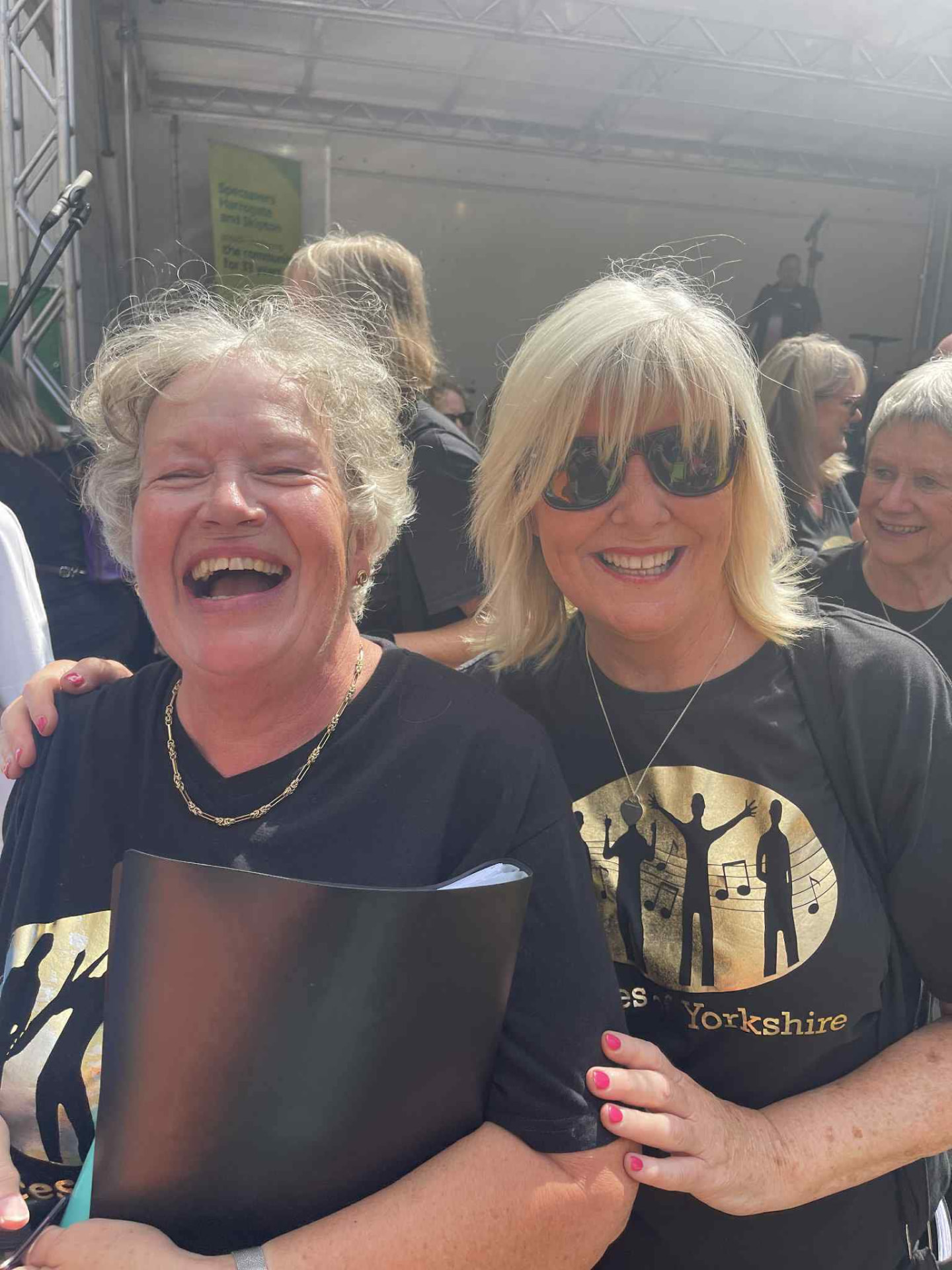 Two VOY members laughing together at a summer gig