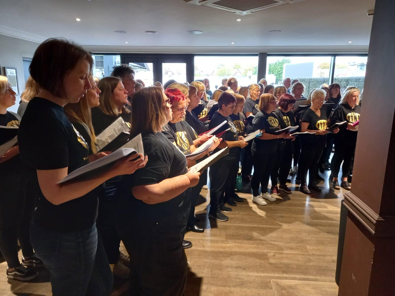 VOY singers holding their lyric sheets during a session