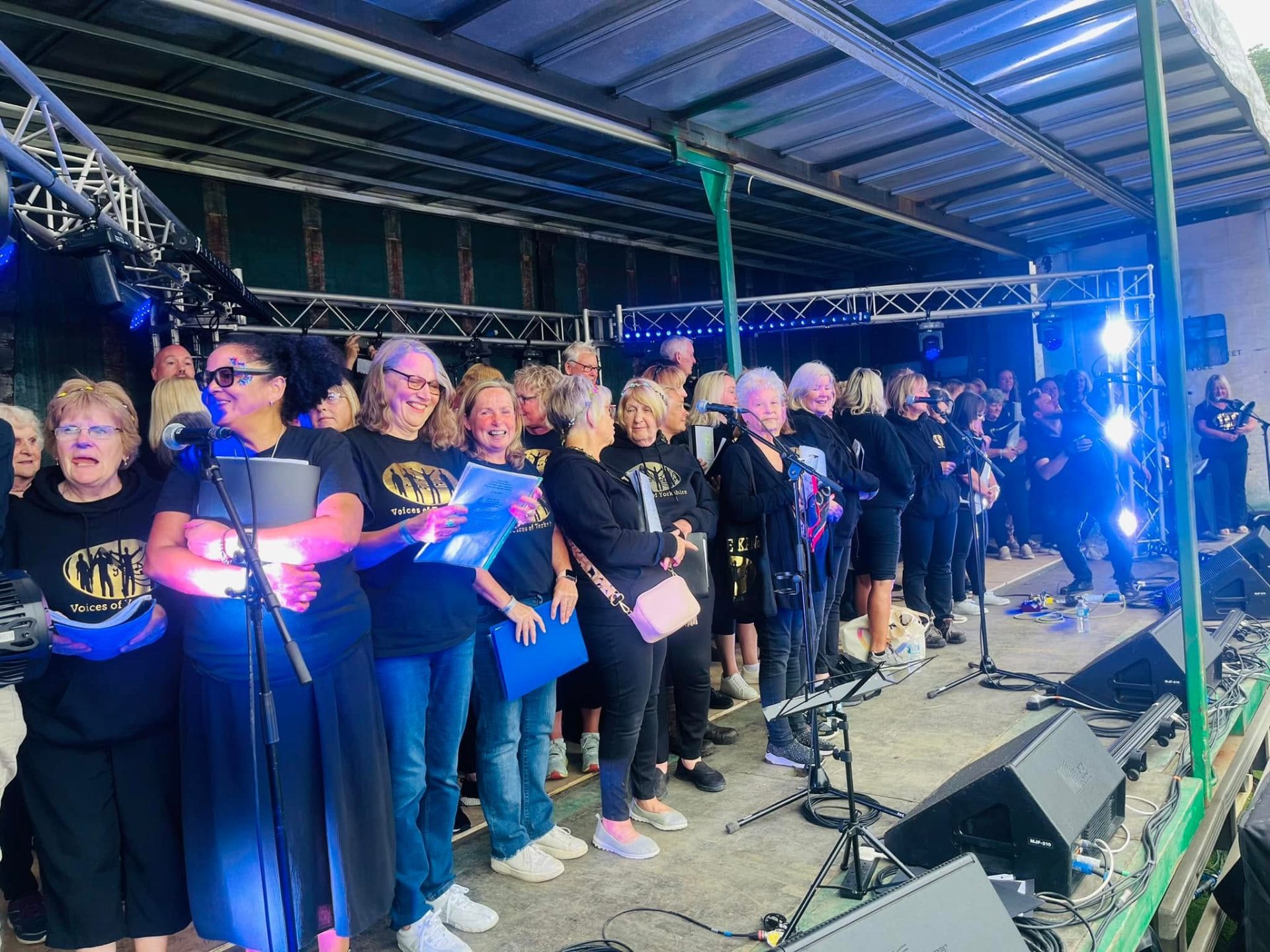 VOY members performing on an outdoor stage in the evening